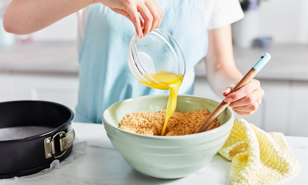 Pouring melted butter into biscuits