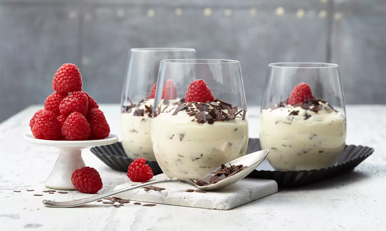 Ein klassischer Pudding verfeinert mit Sahne und Schokoladen-Raspeln schön serviert in Dessertgläsern.