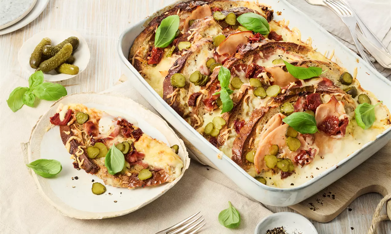 Herzhafter Brotauflauf mit Brotresten, Schinken, getrockneten Tomaten, Käse und Béchamelsoße – einfaches Rezept für ein sättigendes Ofengericht, ideal für Familie und Gäste.