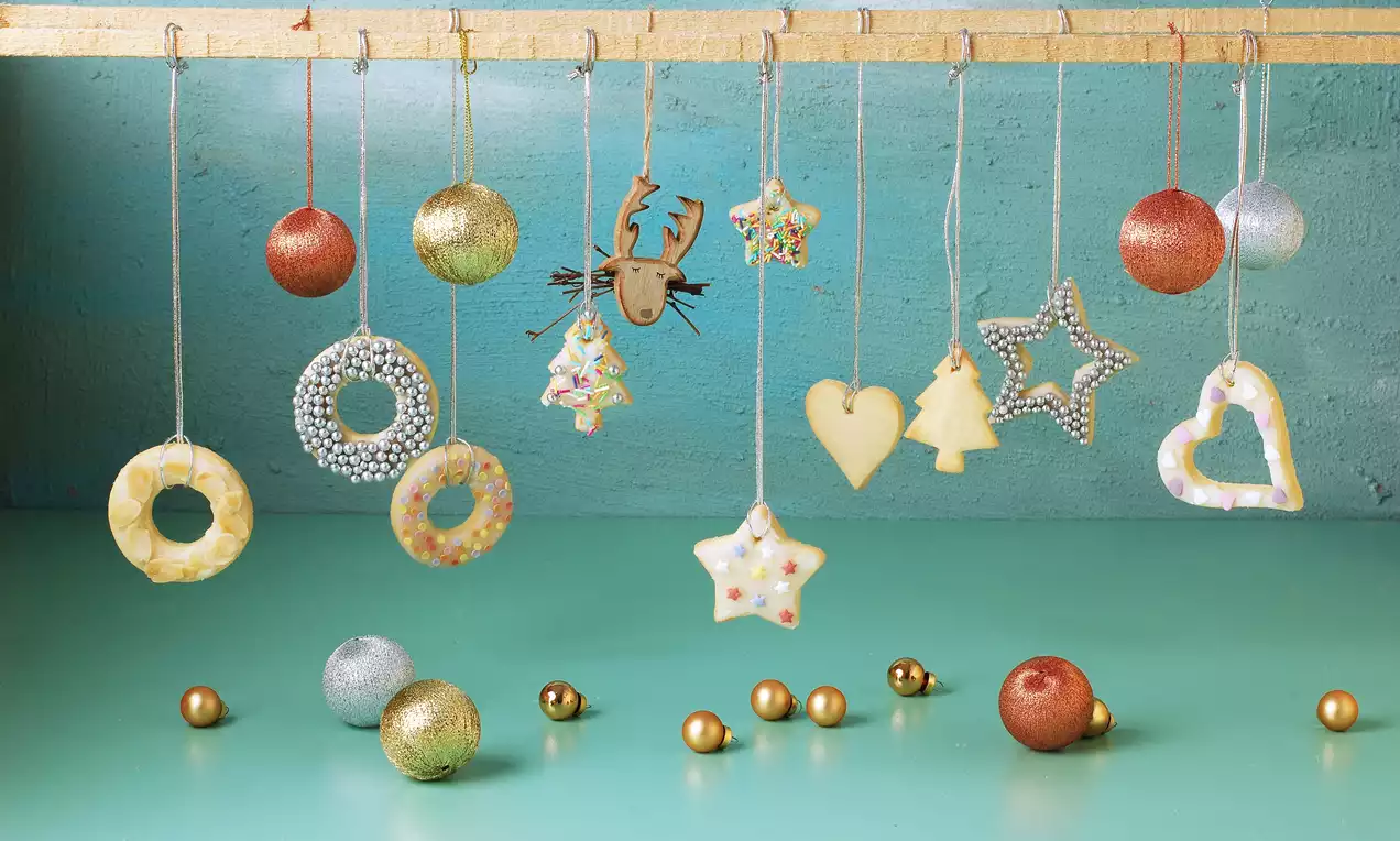 Altın iplerle asılmış, parlak şekerlemelerle süslenmiş, yıldız, kalp ve çam ağacı şeklinde yılbaşı kurabiyeleri