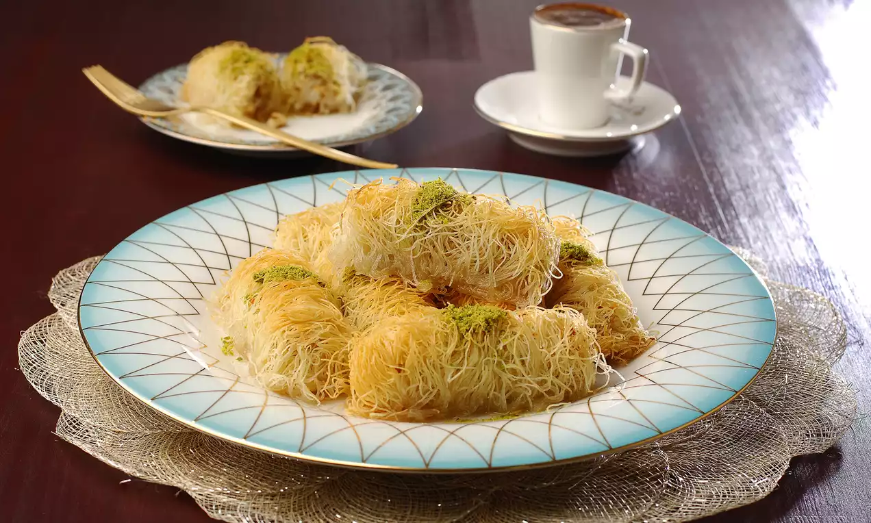 İnce tel kadayıfla sarılmış, altın rengi gevrek dış yüzeyli, üzeri antep fıstığıyla süslenmiş tavukgöğsü sarmaları geniş bir tabakta