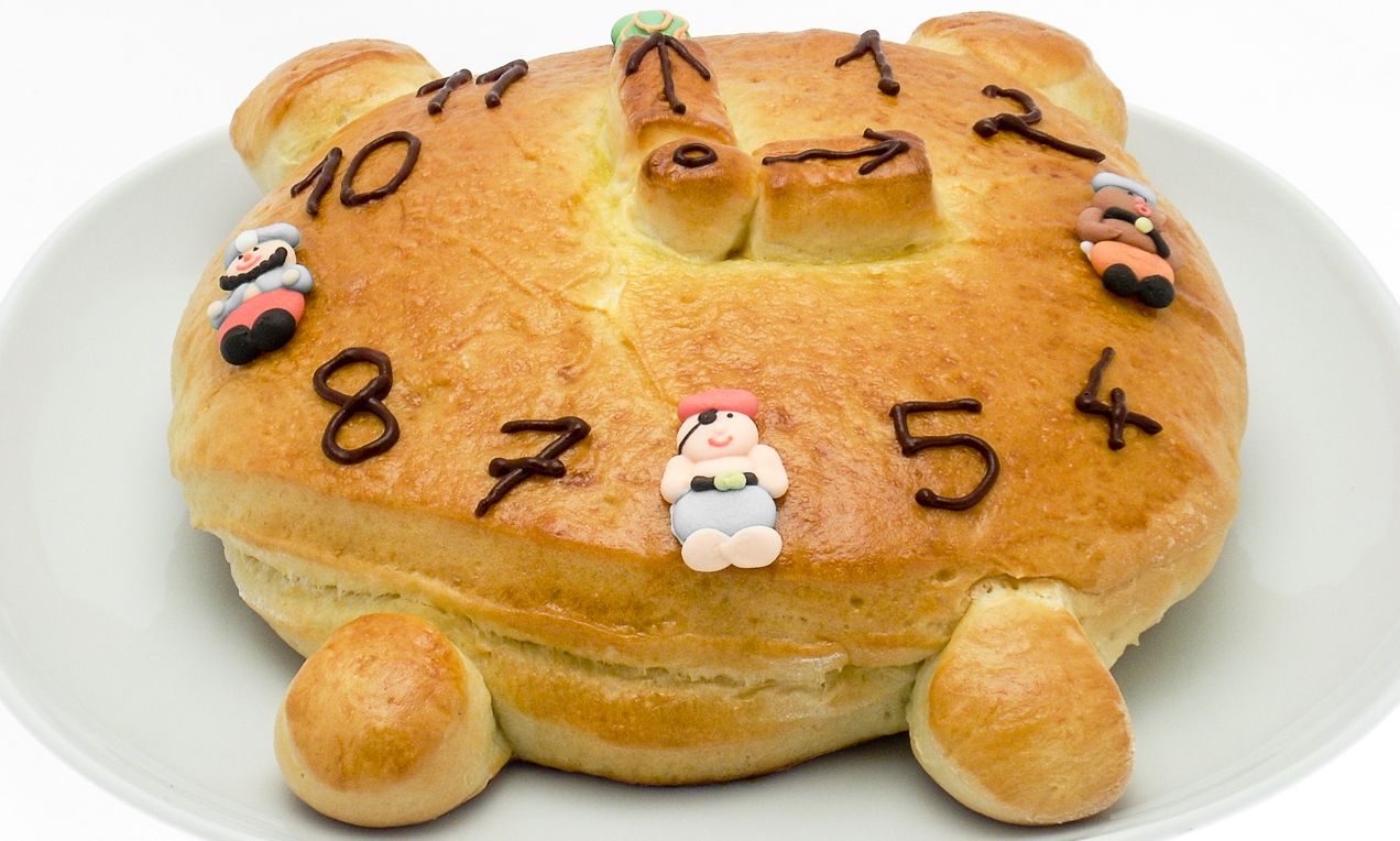 Dolce a forma di sveglia ripieno di crema al gusto cioccolato