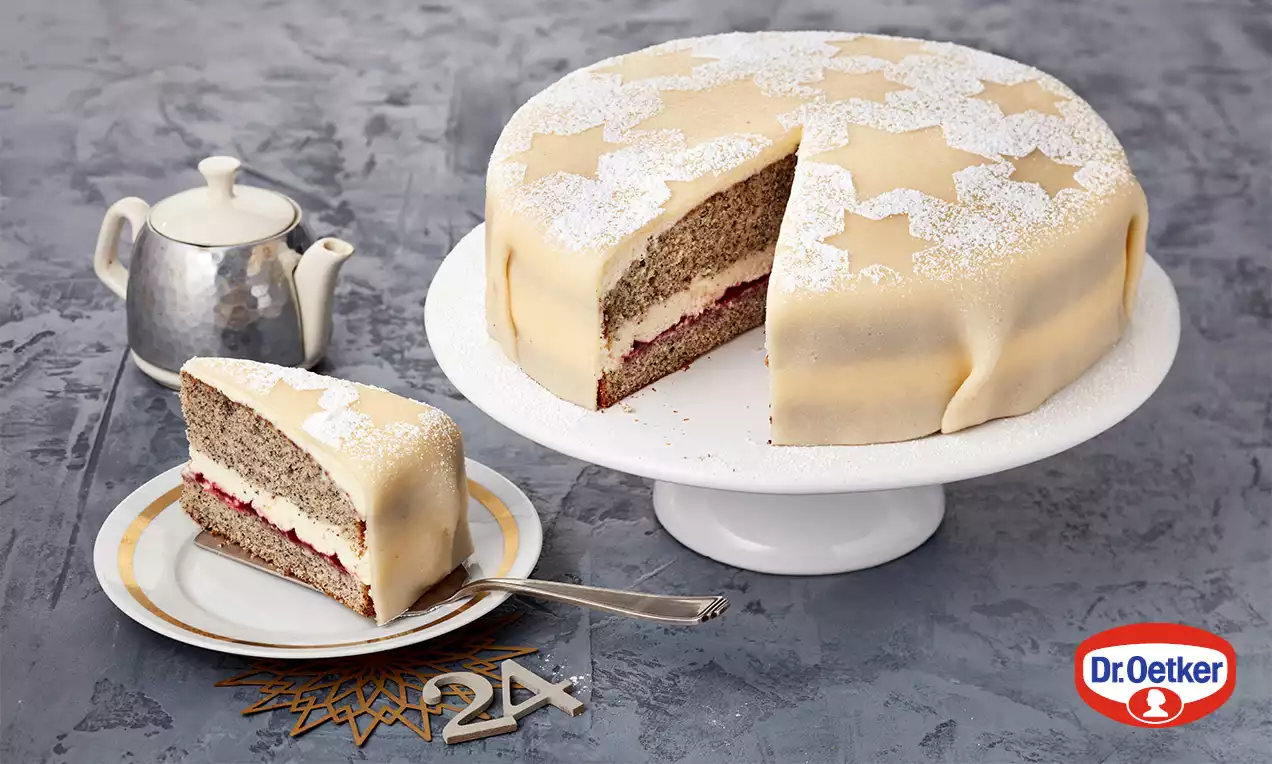 Kulatý makový dort s krémovou náplní a jahodovou vrstvou, potažený světlým marcipánem se vzorem hvězd a poprášený moučkovým cukrem, na stojanu