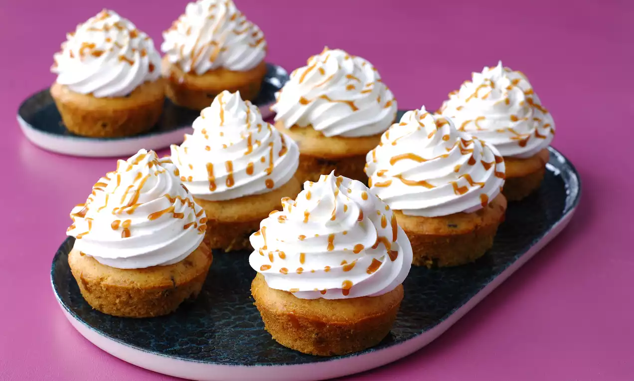 Altın sarısı cupcake tabanı üzerine kabarık beyaz krema şeritleri, karamel sos gezdirmesiyle mavi tabakta zarif bir sunum