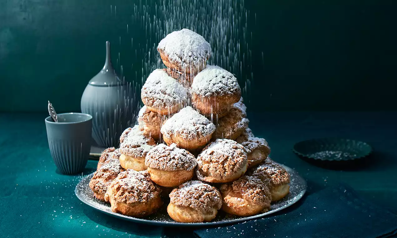 Crackle-Windbeutel mit knuspriger Zimt-Crackelschicht, gefüllt mit heller Fruchtcreme und garniert mit roten Beeren