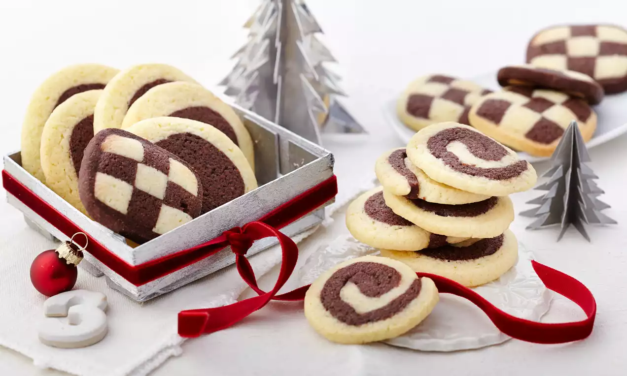 Schwarz-Weiß-Gebäck mit knusprigen, marmorierten und gestreiften Plätzchen aus hellem und dunklem Teig auf weißem Teller