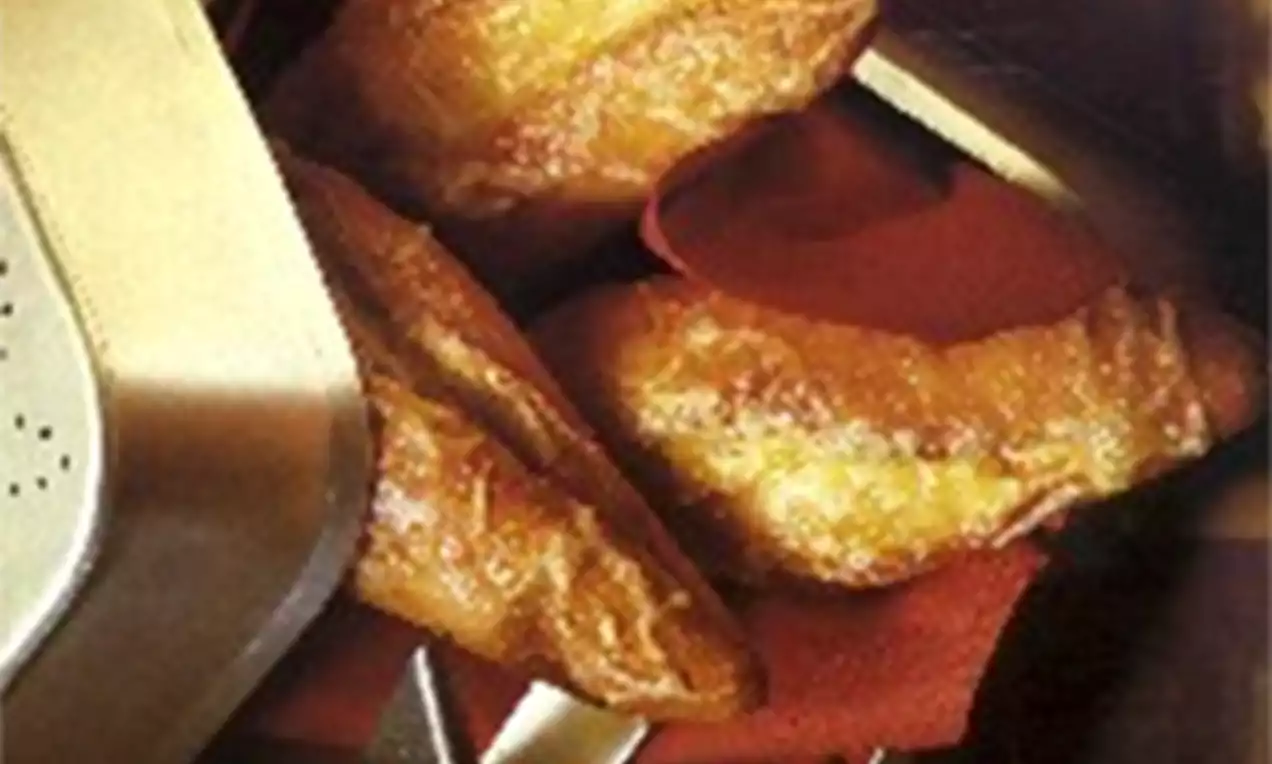 Kaasbroodjes met goudbruine krokante korst en gesmolten kaasvulling op een rode servet naast zilverkleurig bestek