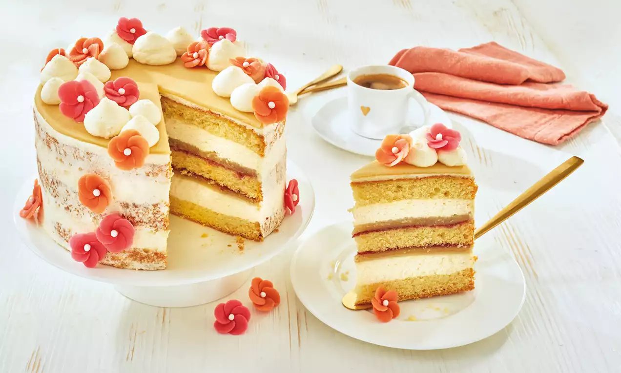 Marzipan-Sahne-Torte mit hellen Teigschichten, Schichten aus Sahne und roter Füllung, dekoriert mit Sahnetupfen und roten Blüten auf weißem Teller