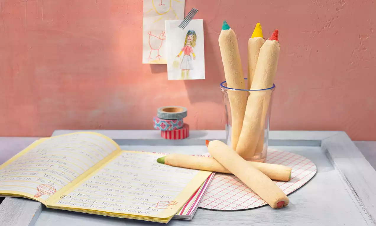 Jestive bojice pastelnih tona s hrskavom teksturom, zašiljenih vrhova obojenih crvenom, zelenom, plavom i žutom, u čaši na bijelom pladnju