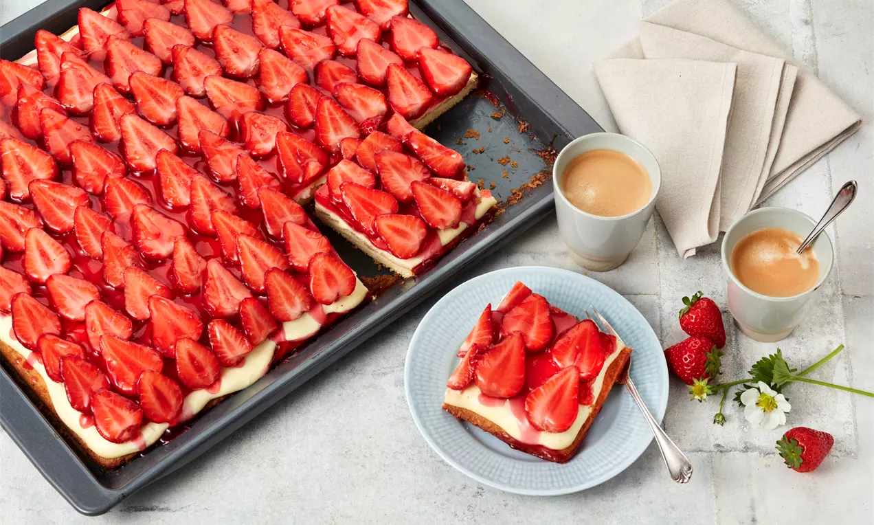 Erdbeerkuchen mit Vanillepudding auf knusprigem Teigboden, cremigem hellgelben Pudding, dicht belegt mit glänzenden roten Erdbeeren