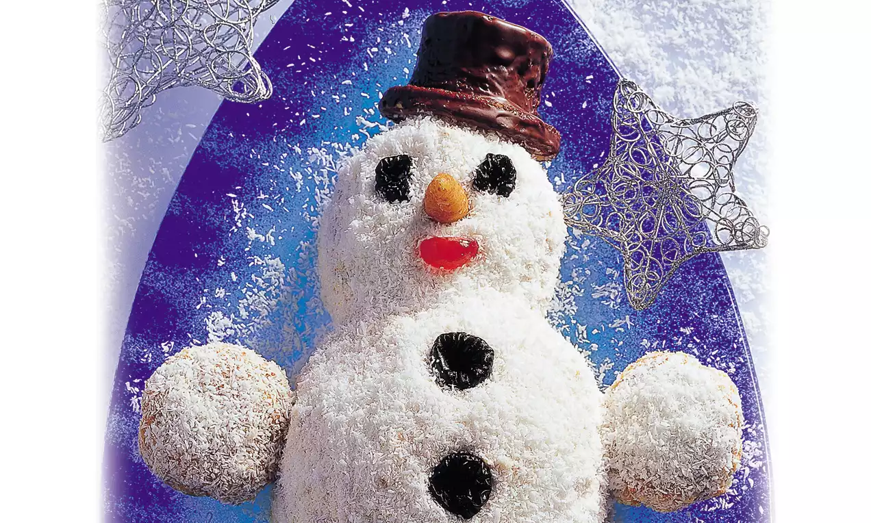 Sneeuwmantaart bedekt met witte kokos, zwarte chocoladedecoraties, oranje en rode details, een chocoladehoed, tegen een paarse achtergrond