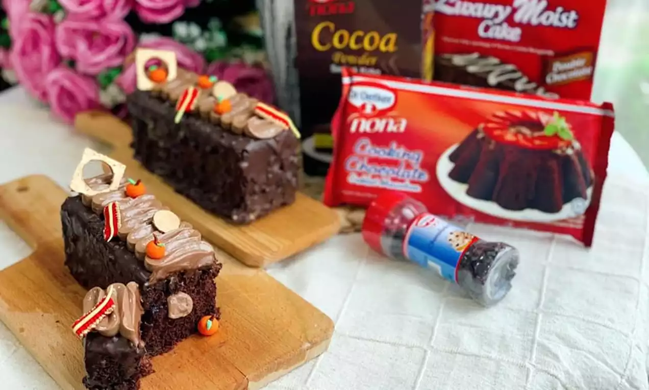 Rich chocolate cheesecake slices covered in glossy dark chocolate glaze, topped with striped candy decorations and coloured sprinkles on wooden boards