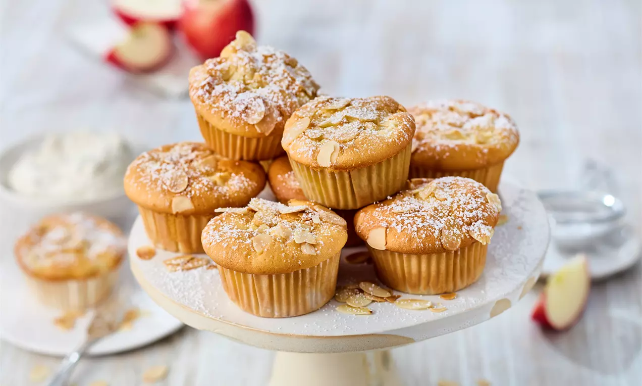 einige saftige Apfelmuffins mit Joghurt, frischen Apfelstücken und lockerem Teig, gestapelt – das einfache Muffin-Rezept für Frühstück, Snack oder Kaffeezeit. Schnell gebacken und super lecker!