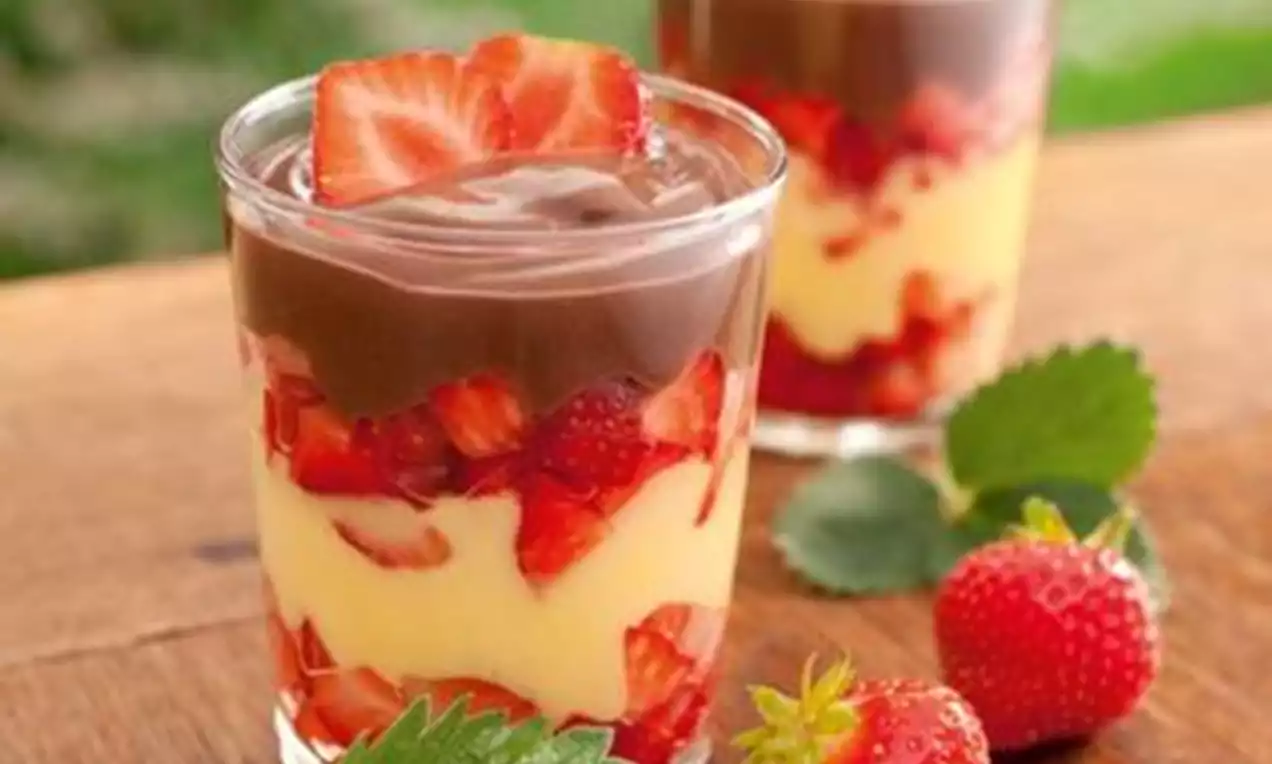 Duo Pudim com duas camadas contrastantes de caramelo castanho e creme amarelo claro em prato branco, calda brilhante escorrendo