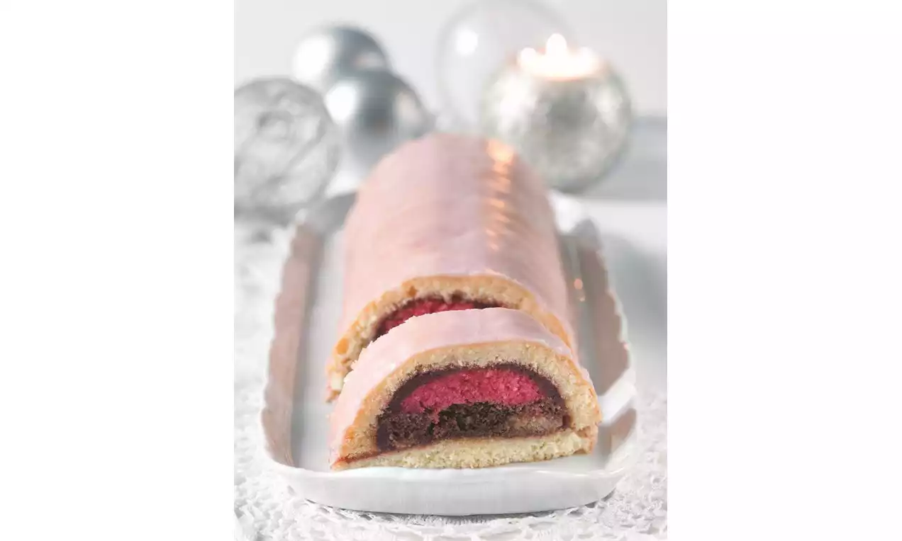 Dlhý puncový tunel s ružovým lesklým povrchom, vnútro v kontraste tmavej kakaovej vrstvy a sýtočervenej textúry na bielom podnose