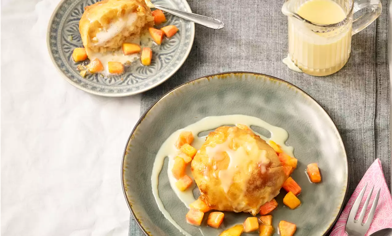 Gebackenes Vanille-Eierlikör-Eis in goldbrauner Knusperhülle, auf grünem Teller mit Eierlikörsoße und kleinen Würfeln aus karamellisiertem Obst drapiert
