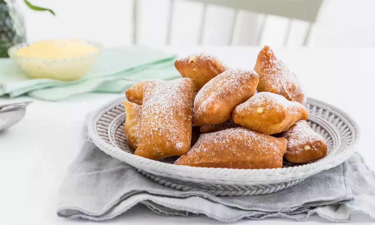 Krapne zlatistohnedej farby, jemne posypané práškovým cukrom, usporiadané na pletenom tanieri položenom na svetlosivej látke